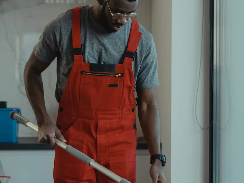 Cleaner in red uniform mopping a commercial floor